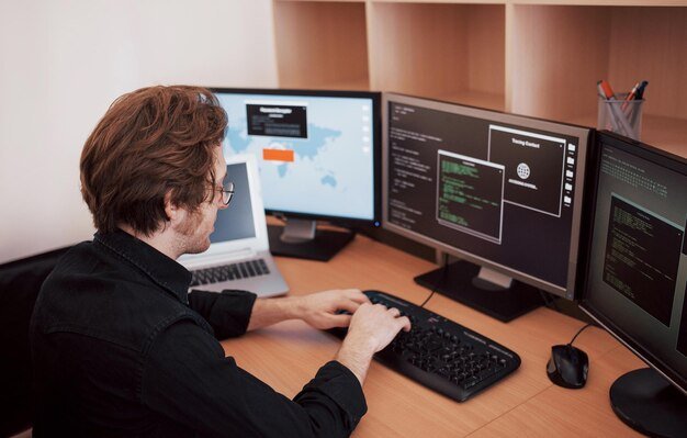 About male-programmer-working-desktop-computer-with-many-monitors-office-software-develop-company-website-design-programming-coding-technologies-1040180-7096